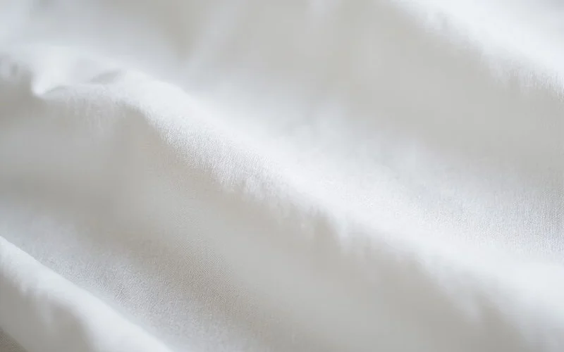 Premium cotton shirting fabric bolts showing various weaves and colors